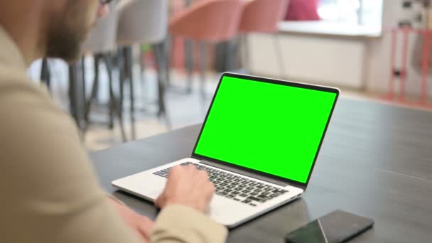 Vista trasera del hombre joven usando el ordenador portátil con pantalla de croma — Vídeo de stock