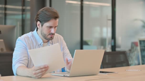 Reifer erwachsener Mann mit Laptop verliert Lesedokumente — Stockvideo