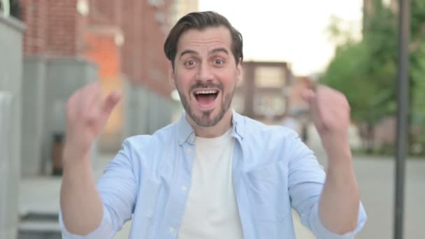 Nadšený muž slaví úspěch při stání venku — Stock video