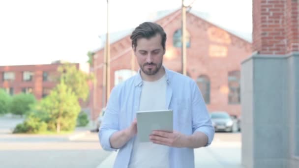 Mann benutzte Tablet beim Gehen auf der Straße — Stockvideo