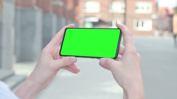 Frau beobachtet Smartphone mit grünem Chroma-Bildschirm — Stockvideo