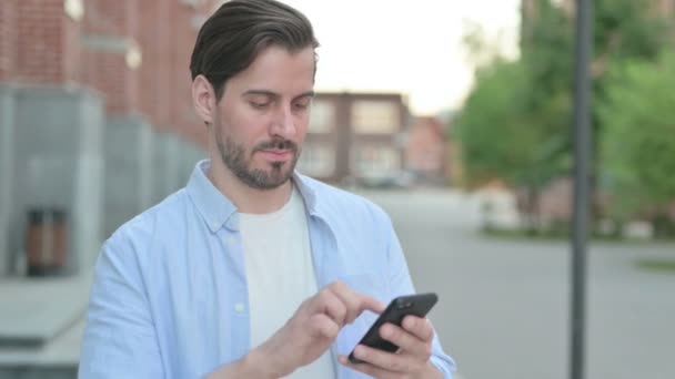 Mann feiert im Stehen auf Smartphone — Stockvideo