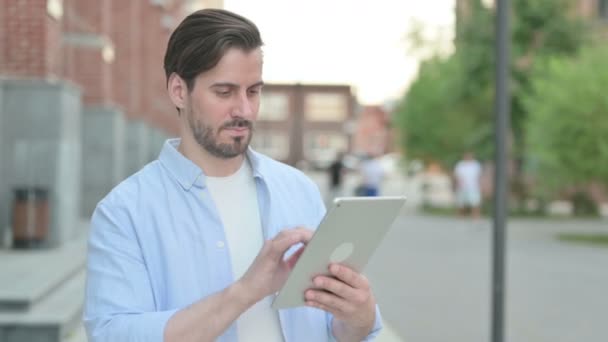 Hombre Browing Internet en la tableta mientras está de pie al aire libre — Vídeos de Stock