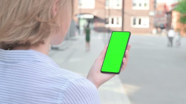 Mujer mirando Smartphone con pantalla de croma verde — Vídeo de stock