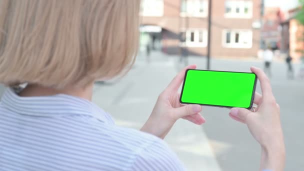 Frau benutzt Smartphone mit grünem Chroma-Bildschirm — Stockvideo