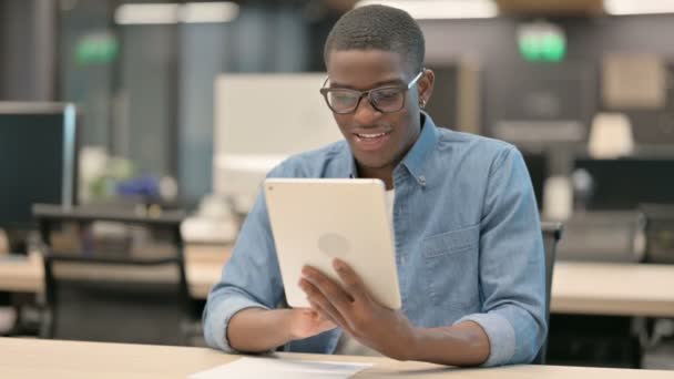 Joven afroamericano exitoso celebrando en la tableta en la oficina — Vídeos de Stock