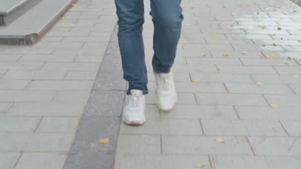 Detailní záběr záběr nohou člověka kráčejícího po chodníku — Stock video