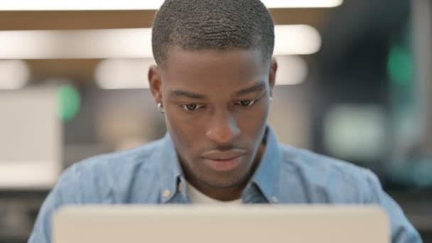 Framgångsrik ung afrikansk amerikansk man firar på laptop — Stockvideo