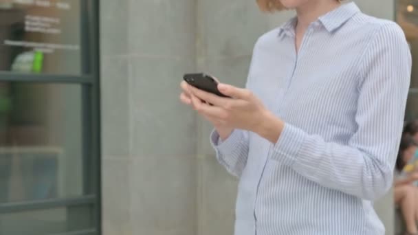Chůze žena pomocí Smartphone, prohlížení internetu