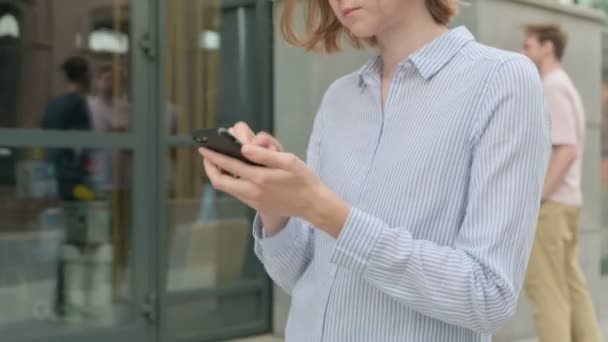 Mulher usando Smartphone enquanto caminha na rua — Vídeo de Stock