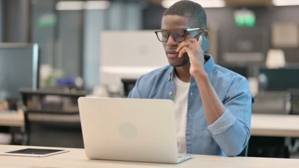 Joven afroamericano hablando por teléfono en el trabajo — Vídeos de Stock