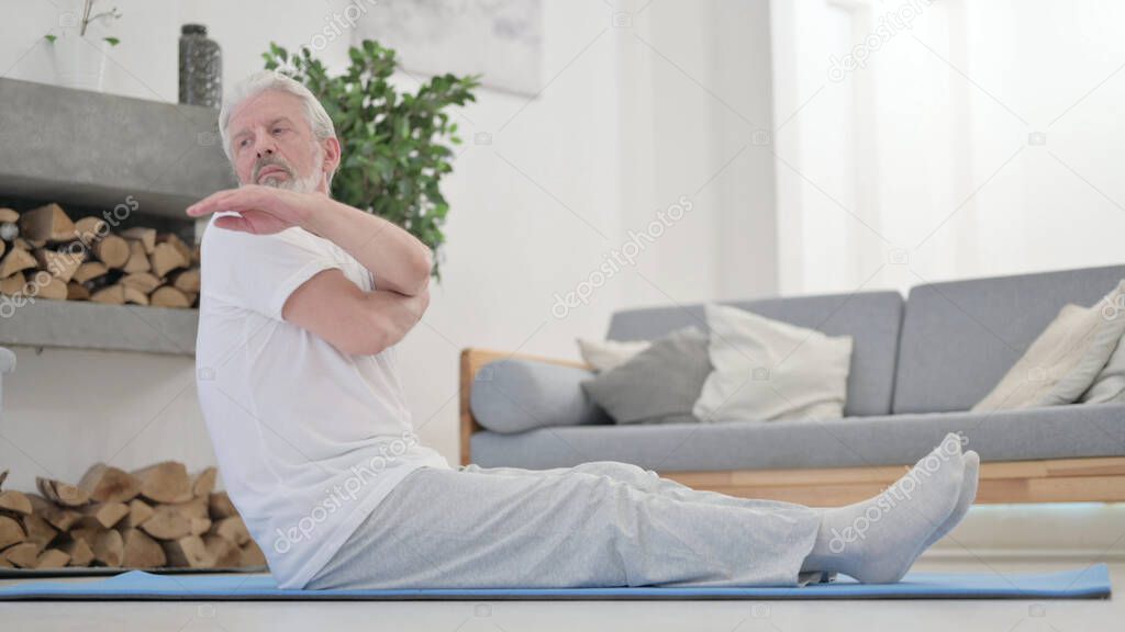 Old Man doing Stretches on Excercise Mat at Home