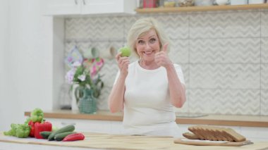 Mutfakta Elma Tutarken Yaşlı Kadın Başparmaklarını Gösteriyor