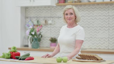 Mutfakta dikilirken Yaşlı Kadın Kameraya Bakıyor