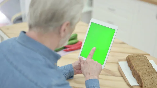 Old Man Using Tablet with Green Screen in Kitchen