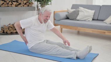 Yaşlı adam evde gerinirken sırt ağrısı çekiyor.