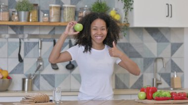 Mutfakta Elma Tutarken Afrikalı Kadın Başparmaklarını Gösteriyor