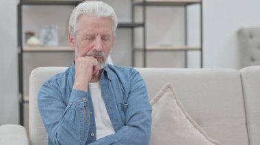 Yaşlı adam koltukta otururken kestiriyor. 