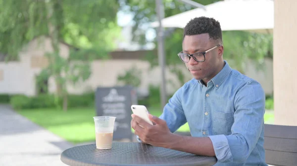 Cafe 'de akıllı telefon kullanan Afrikalı adam. — Stok fotoğraf