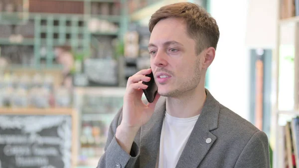 Porträtt av den unge mannen som pratar i telefon — Stockfoto