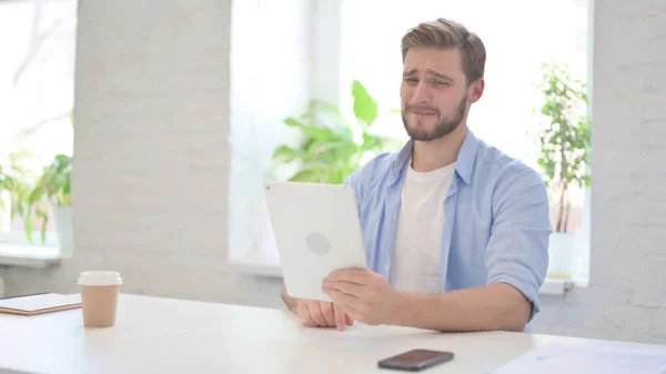 Junger Mann reagiert auf Verlust mit Tablet — Stockfoto