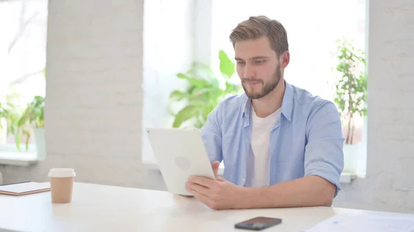 Junger Mann nutzt Tablet im modernen Büro — Stockfoto