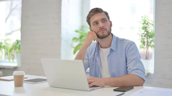 Junger Mann denkt im modernen Büro — Stockfoto