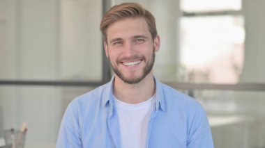 Kafasını sallayan genç adamın portresi Evet işareti 