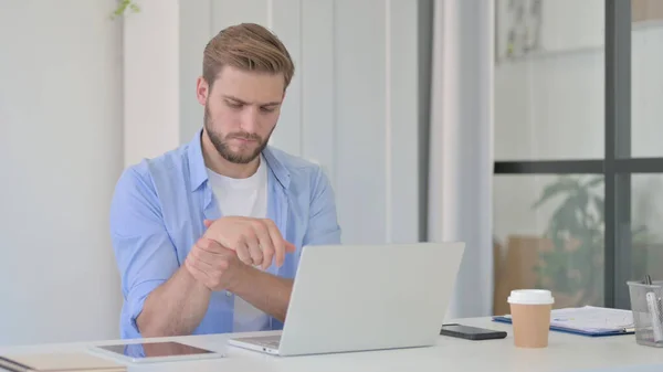 Junger Mann bei der Arbeit mit Handgelenkschmerzen — Stockfoto