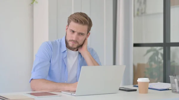 Junger Mann hat Nackenschmerzen bei der Arbeit — Stockfoto