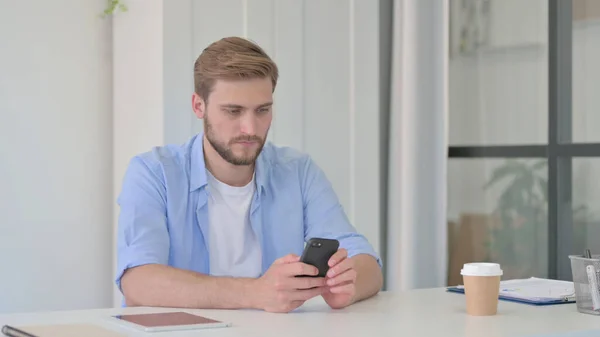 Young Man using Smartphone in Office — Stock Photo, Image