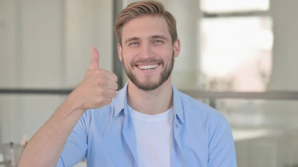 Portræt af ung mand viser tommelfingre op tegn - Stock-foto