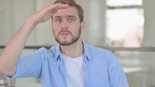 Retrato de un joven mirando a su alrededor, buscando — Foto de Stock