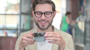 Mutlu genç adam kahve içerken eğleniyor.