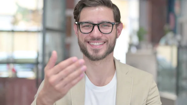 Retrato de un joven apuntando a la cámara, invitando — Foto de Stock