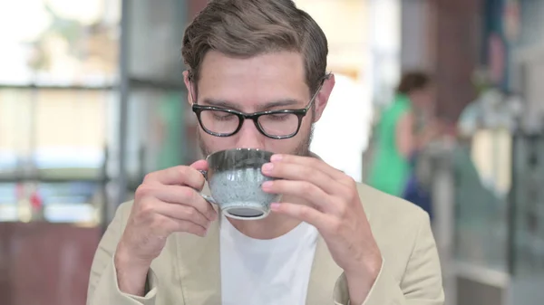 Portret van een jonge man die koffie drinkt op het werk — Stockfoto