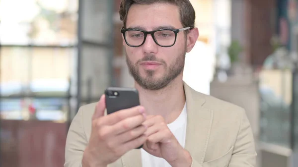 Portrét prohlížení mladého muže na chytrém telefonu — Stock fotografie