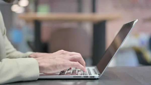 Großaufnahme männlicher Hände, die auf Laptop tippen, seitliche Haltung — Stockfoto