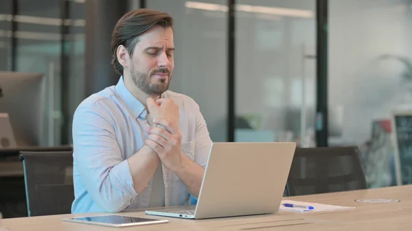 Reife erwachsene Mann bei der Arbeit mit Handgelenkschmerzen — Stockfoto