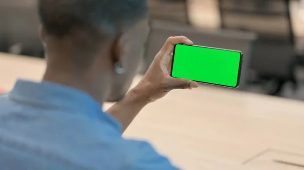 Uomo africano guardando Smartphone con schermo cromato — Foto Stock
