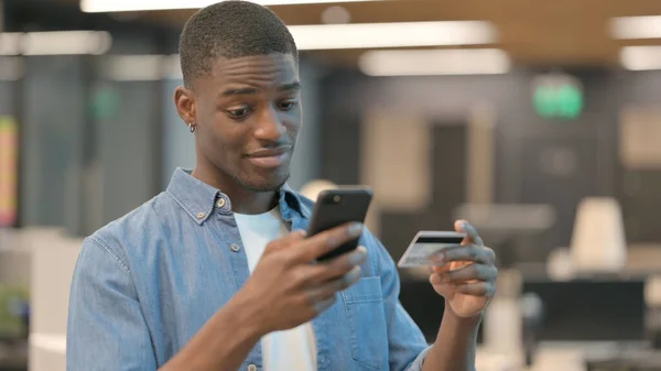 非洲年轻人在智能手机上在线支付 — 图库照片