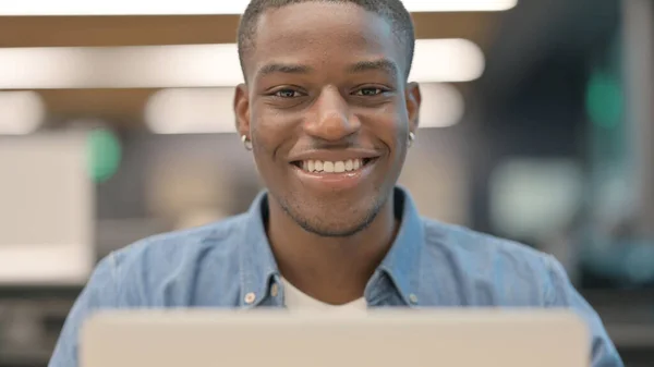 Afrikansk man ler mot kameran på jobbet — Stockfoto