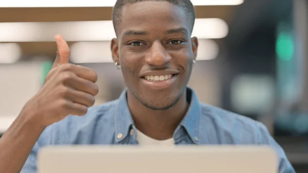 Afrikansk man visar tummen upp på jobbet — Stockfoto