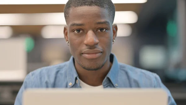 Afrikansk man tittar på kameran på jobbet — Stockfoto