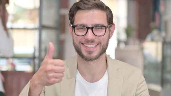 Retrato de un joven mostrando el signo de pulgares hacia arriba — Foto de Stock