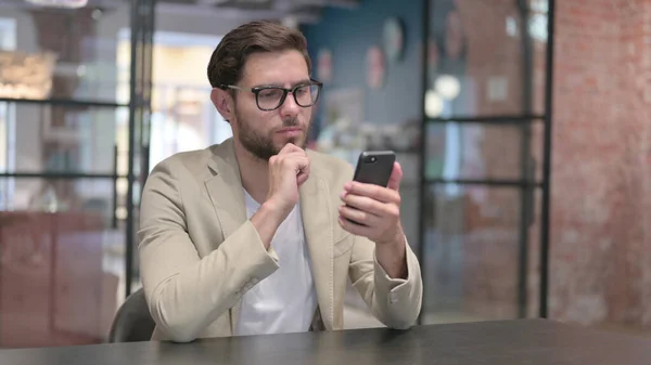 Attractive Young Man Browsing on Smartphone at Work — Stock Photo, Image