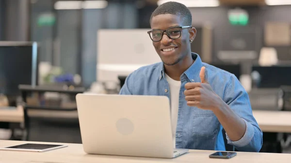 Ung afrikansk man visar tummen upp på jobbet — Stockfoto