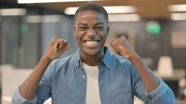 Spännande ung afrikansk man firar framgång — Stockfoto