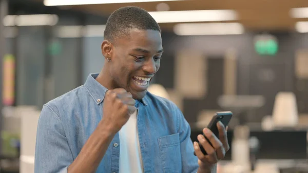 Mladý Afričan slaví na smartphonu — Stock fotografie
