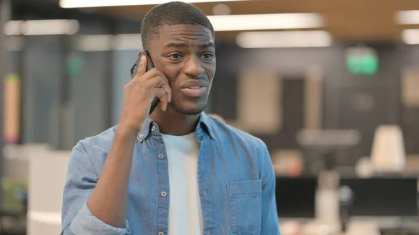 Rozzlobený mladý Afričan mluví po telefonu — Stock fotografie